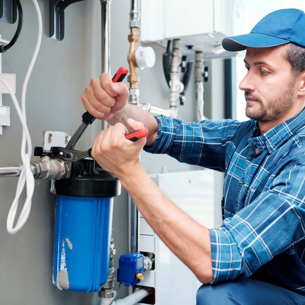 young-plumber-or-technician-installing-or-repairing-system-of-water-filtration.jpg